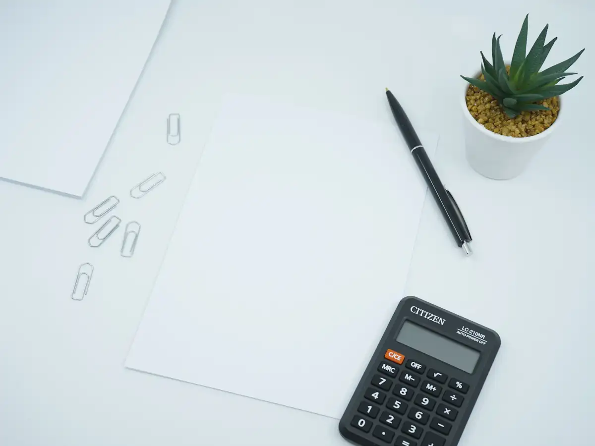 Calculator and pen on printed paper for cost calculations