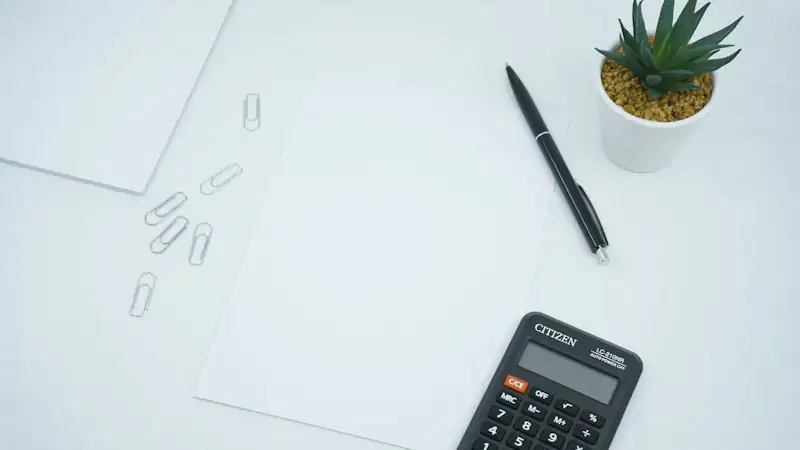 Calculator and pen on printed paper for cost calculations