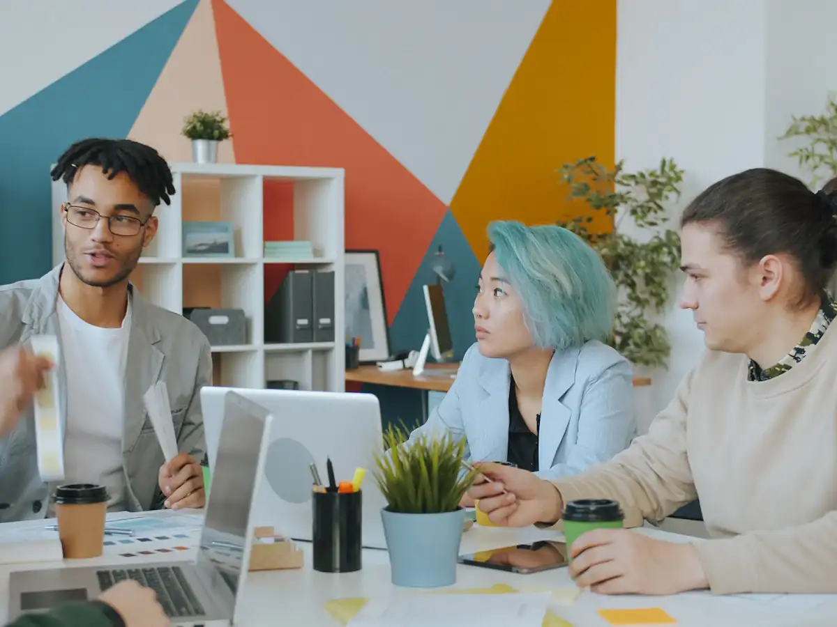Diverse group of four people collaborating in a colourful workspace