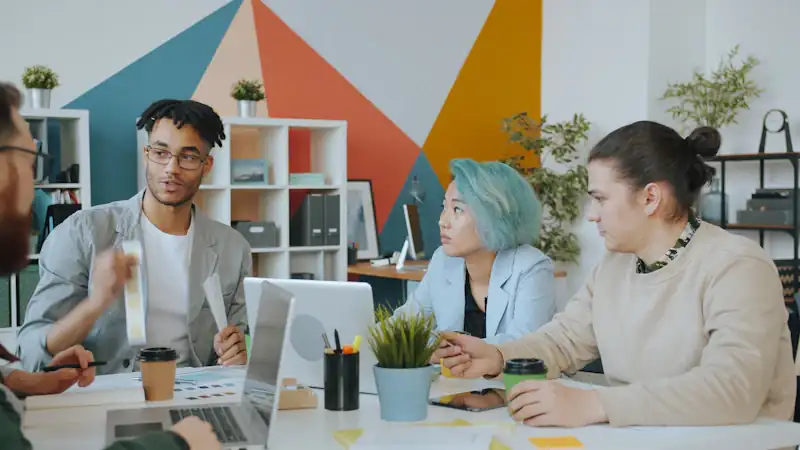 Diverse group of four people collaborating in a colourful workspace