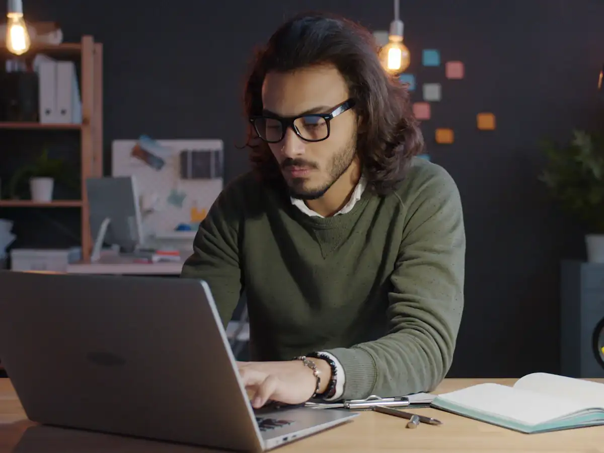 Consultant working late on a laptop in a dimly lit office