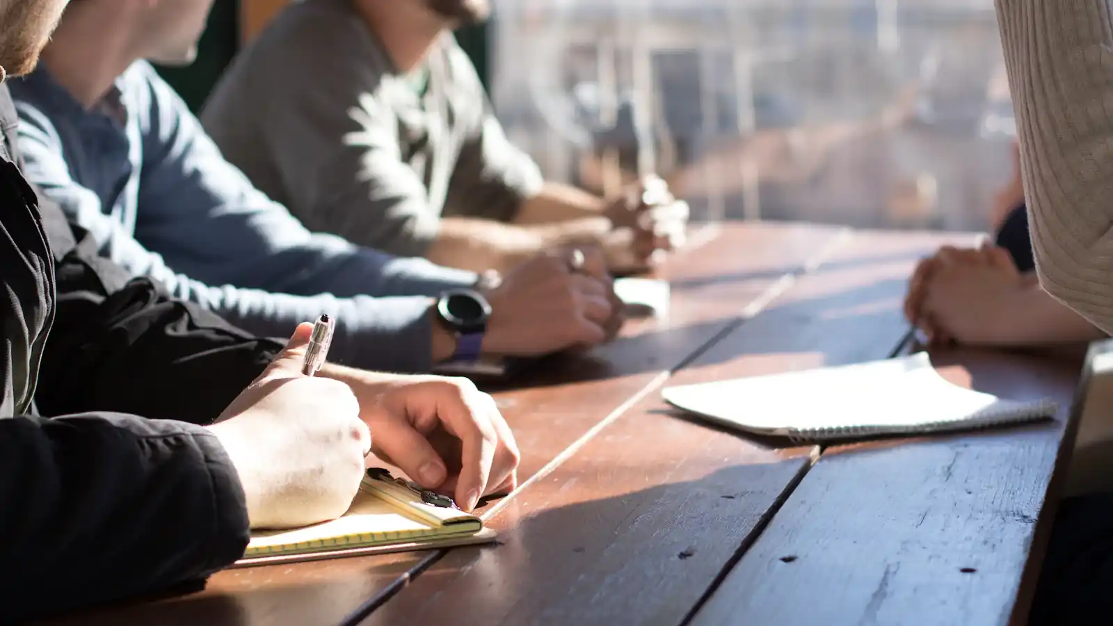 Recruitment team meeting around a table with notes and pens