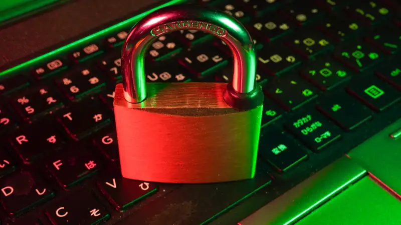 Red padlock on a black computer keyboard representing data security