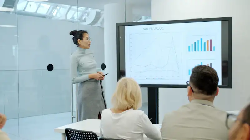 Woman presenting a graph to an audience of colleagues